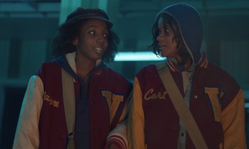 Movie still from “The Silent Twins” (2022), directed by Agnieszka Smoczynska – A couple of people standing next to each other; Medium shot, Over the shoulder angle