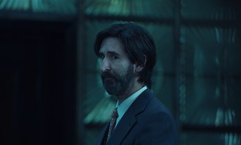 Movie still from “The Silent Twins” (2022), directed by Agnieszka Smoczynska – A man in a suit and tie looking to his left; Close Up shot, Low angle