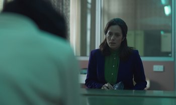 Movie still from “The Silent Twins” (2022), directed by Agnieszka Smoczynska – A woman sitting in front of a mirror looking at herself in the mirror; Medium shot, Over the shoulder angle