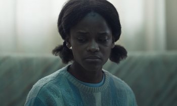 Movie still from “The Silent Twins” (2022), directed by Agnieszka Smoczynska – A young woman with her eyes wide open; Close Up shot, Low angle