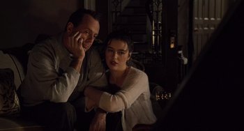 Movie still from “The Sixth Sense” (1999), directed by M. Night Shyamalan – A man and a woman sitting next to each other in a room; Medium shot, High angle