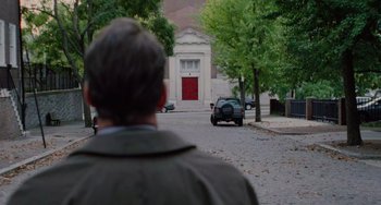 Movie still from “The Sixth Sense” (1999), directed by M. Night Shyamalan – A man is standing on the sidewalk looking at a car; Extreme Wide shot, Over the shoulder angle
