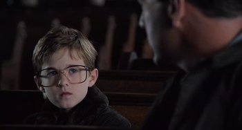 Movie still from “The Sixth Sense” (1999), directed by M. Night Shyamalan – A young boy wearing glasses sitting in front of an older man; Close Up shot, Over the shoulder angle