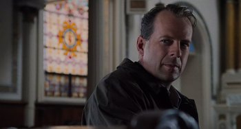 Movie still from “The Sixth Sense” (1999), directed by M. Night Shyamalan – A man sitting in front of a stained glass window; Close Up shot, Low angle