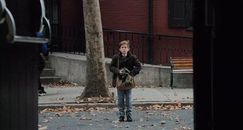 Movie still from “The Sixth Sense” (1999), directed by M. Night Shyamalan – A young boy standing on the side of the street; Wide shot, High angle