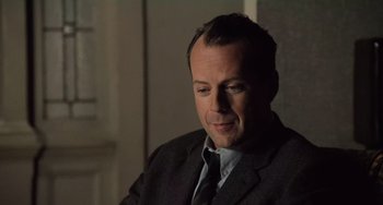 Movie still from “The Sixth Sense” (1999), directed by M. Night Shyamalan – A person wearing a suit and tie; Close Up shot, Over the shoulder angle