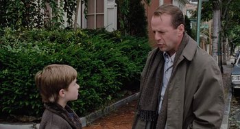 Movie still from “The Sixth Sense” (1999), directed by M. Night Shyamalan – A man and a boy are standing in front of a building; Medium shot, Over the shoulder angle