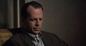 Movie still from “The Sixth Sense” (1999), directed by M. Night Shyamalan – A man in a suit and tie looking to his left; Close Up shot, Low angle