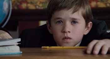 Movie still from “The Sixth Sense” (1999), directed by M. Night Shyamalan – A young boy sitting at a table with a pencil; Close Up shot, High angle