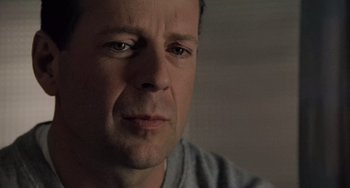 Movie still from “The Sixth Sense” (1999), directed by M. Night Shyamalan – A man's face in a dark room; Close Up shot, Over the shoulder angle