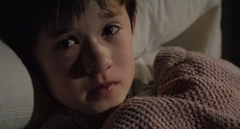 Movie still from “The Sixth Sense” (1999), directed by M. Night Shyamalan – A child laying in a bed; Close Up shot, High angle