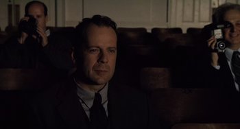 Movie still from “The Sixth Sense” (1999), directed by M. Night Shyamalan – A man wearing a suit and tie sitting in front of a window; Close Up shot, Over the shoulder angle
