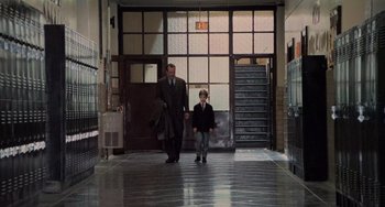 Movie still from “The Sixth Sense” (1999), directed by M. Night Shyamalan – A man and a boy walking down a hall way; Wide shot, Over the shoulder angle