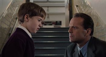 Movie still from “The Sixth Sense” (1999), directed by M. Night Shyamalan – A man and a young boy in front of a staircase; Close Up shot, Over the shoulder angle