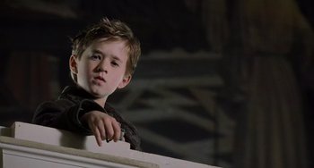 Movie still from “The Sixth Sense” (1999), directed by M. Night Shyamalan – A young boy leaning against a wall looking to his left; Close Up shot, Low angle
