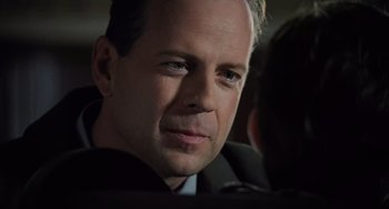 Movie still from “The Sixth Sense” (1999), directed by M. Night Shyamalan – A man in a suit and tie looking into the distance; Close Up shot, Over the shoulder angle