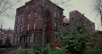 Movie still from “The Sixth Sense” (1999), directed by M. Night Shyamalan – A very tall building with a lot of plants growing on it; Extreme Wide shot, Low angle