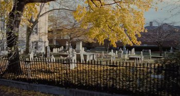 A cemetery with many crosses and a fence
