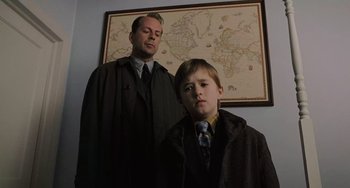 Movie still from “The Sixth Sense” (1999), directed by M. Night Shyamalan – A man and a young boy standing in front of a map; Medium shot, Low angle
