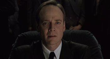 Movie still from “The Sixth Sense” (1999), directed by M. Night Shyamalan – A person wearing a suit and tie; Close Up shot, Low angle