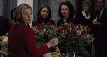 Movie still from “The Sixth Sense” (1999), directed by M. Night Shyamalan – A woman in a red jacket holding a bunch of roses; Medium shot, Over the shoulder angle