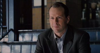 Movie still from “The Sixth Sense” (1999), directed by M. Night Shyamalan – A person wearing a suit and tie; Close Up shot, Over the shoulder angle