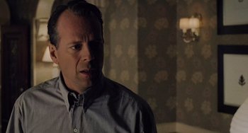 Movie still from “The Sixth Sense” (1999), directed by M. Night Shyamalan – A man standing in front of a wall with flowers; Close Up shot, Over the shoulder angle
