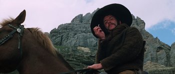 Movie still from “The Specialists” (1969), directed by Sergio Corbucci – A man smoking a cigarette while sitting on a horse; Close Up shot, Low angle