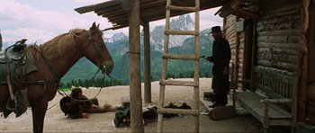 Movie still from “The Specialists” (1969), directed by Sergio Corbucci – A man standing next to a horse on top of a hill; Wide shot, Low angle
