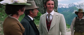 Movie still from “The Specialists” (1969), directed by Sergio Corbucci – A man in a suit and tie standing next to another man in a hat; Medium shot, Over the shoulder angle