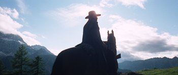 Movie still from “The Specialists” (1969), directed by Sergio Corbucci – A man riding a horse in the middle of a field; Wide shot, Low angle
