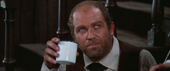 Movie still from “The Specialists” (1969), directed by Sergio Corbucci – An older man holding a coffee cup in his hand; Close Up shot, Low angle