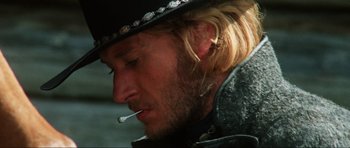 Movie still from “The Specialists” (1969), directed by Sergio Corbucci – A person wearing a hat and smoking a cigarette; Close Up shot, Low angle