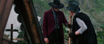 Movie still from “The Specialists” (1969), directed by Sergio Corbucci – A man wearing a hat and a red coat; Medium shot, Over the shoulder angle