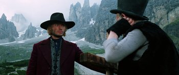 Movie still from “The Specialists” (1969), directed by Sergio Corbucci – A man in a hat and a red jacket and a woman in a red jacket and a black hat; Medium shot, Low angle