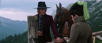 Movie still from “The Specialists” (1969), directed by Sergio Corbucci – A man wearing a hat standing next to a brown horse; Medium shot, Low angle