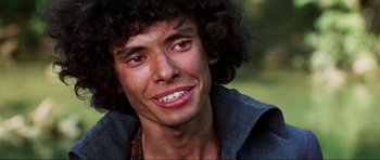 Movie still from “The Specialists” (1969), directed by Sergio Corbucci – A person with curly hair smiling; Close Up shot, Low angle