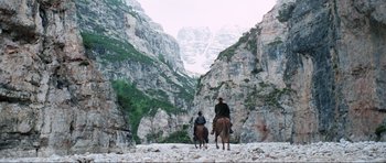 Movie still from “The Specialists” (1969), directed by Sergio Corbucci – Two people on horseback riding through the mountains; Extreme Wide shot, Low angle