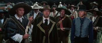 Movie still from “The Specialists” (1969), directed by Sergio Corbucci – A group of men standing next to each other holding guns; Medium shot, Low angle