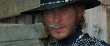 Movie still from “The Specialists” (1969), directed by Sergio Corbucci – A person wearing a hat smoking a cigarette; Close Up shot, Low angle