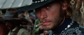 Movie still from “The Specialists” (1969), directed by Sergio Corbucci – A person wearing a hat and smoking a cigarette; Close Up shot, Low angle