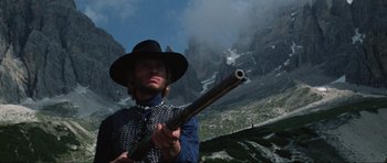 Movie still from “The Specialists” (1969), directed by Sergio Corbucci – A man holding a rifle in a field; Medium shot, Low angle