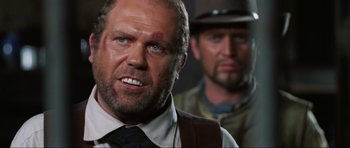 Movie still from “The Specialists” (1969), directed by Sergio Corbucci – A man in a suit and tie with a beard; Close Up shot, Low angle