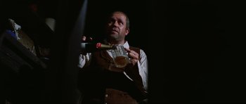 Movie still from “The Specialists” (1969), directed by Sergio Corbucci – A man holding a bottle and a glass of beer; Close Up shot, Low angle