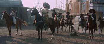 Movie still from “The Specialists” (1969), directed by Sergio Corbucci – A group of men on horseback riding on a dirt field; Wide shot, Low angle