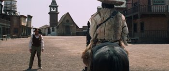 Movie still from “The Specialists” (1969), directed by Sergio Corbucci – A person riding a horse in a dirt field; Wide shot, Low angle