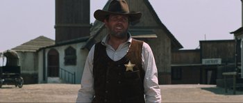 Movie still from “The Specialists” (1969), directed by Sergio Corbucci – A man wearing a hat and a vest with a sheriff's star on it; Medium shot, Low angle