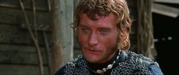 Movie still from “The Specialists” (1969), directed by Sergio Corbucci – A person wearing chains and a black shirt; Close Up shot, Low angle