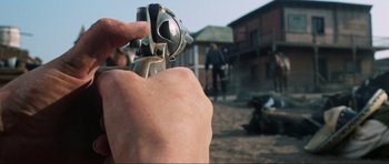Movie still from “The Specialists” (1969), directed by Sergio Corbucci – A person holding a gun in their hand; Extreme Close Up shot, Low angle