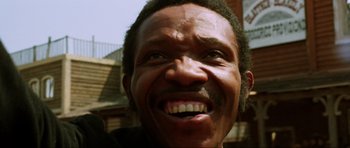 Movie still from “The Specialists” (1969), directed by Sergio Corbucci – A man's face with a big smile; Close Up shot, Low angle